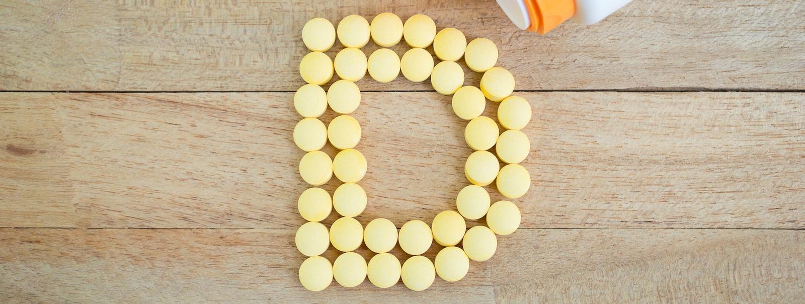 Pilules jaunes formant la lettre D sur une surface en bois