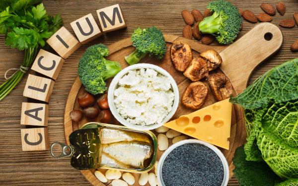 Aliments riches en calcium entourés de cubes de bois épelant « Calcium »