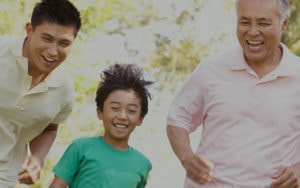 Older man, man and young boy laughing