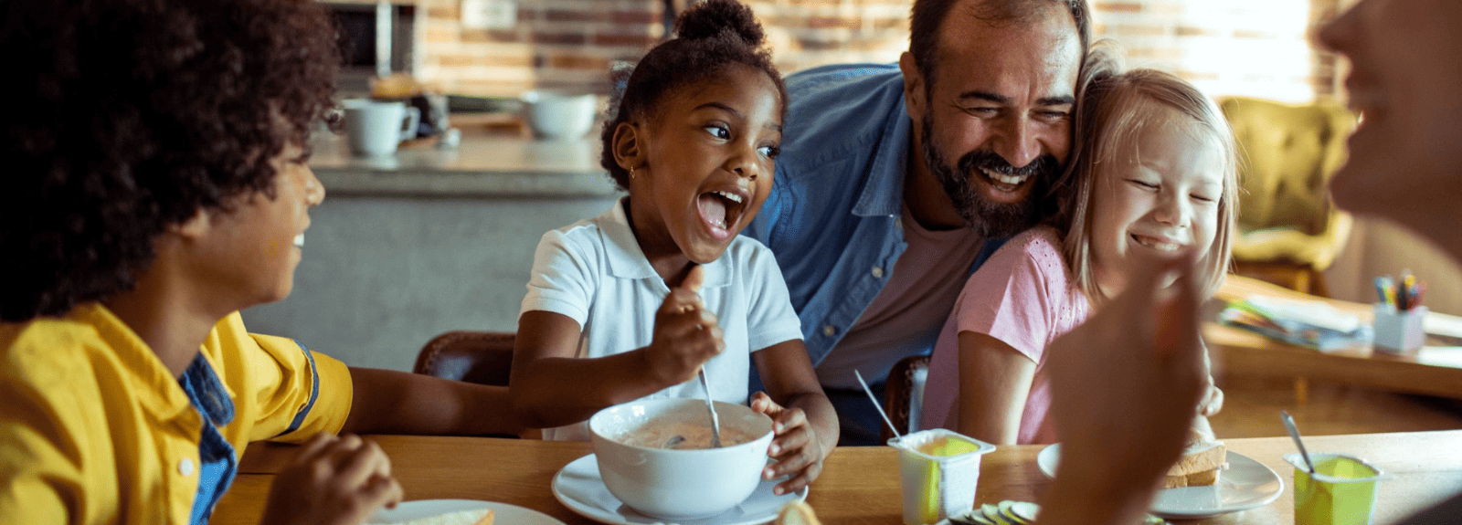 Kids and a man laughing while eating cereal